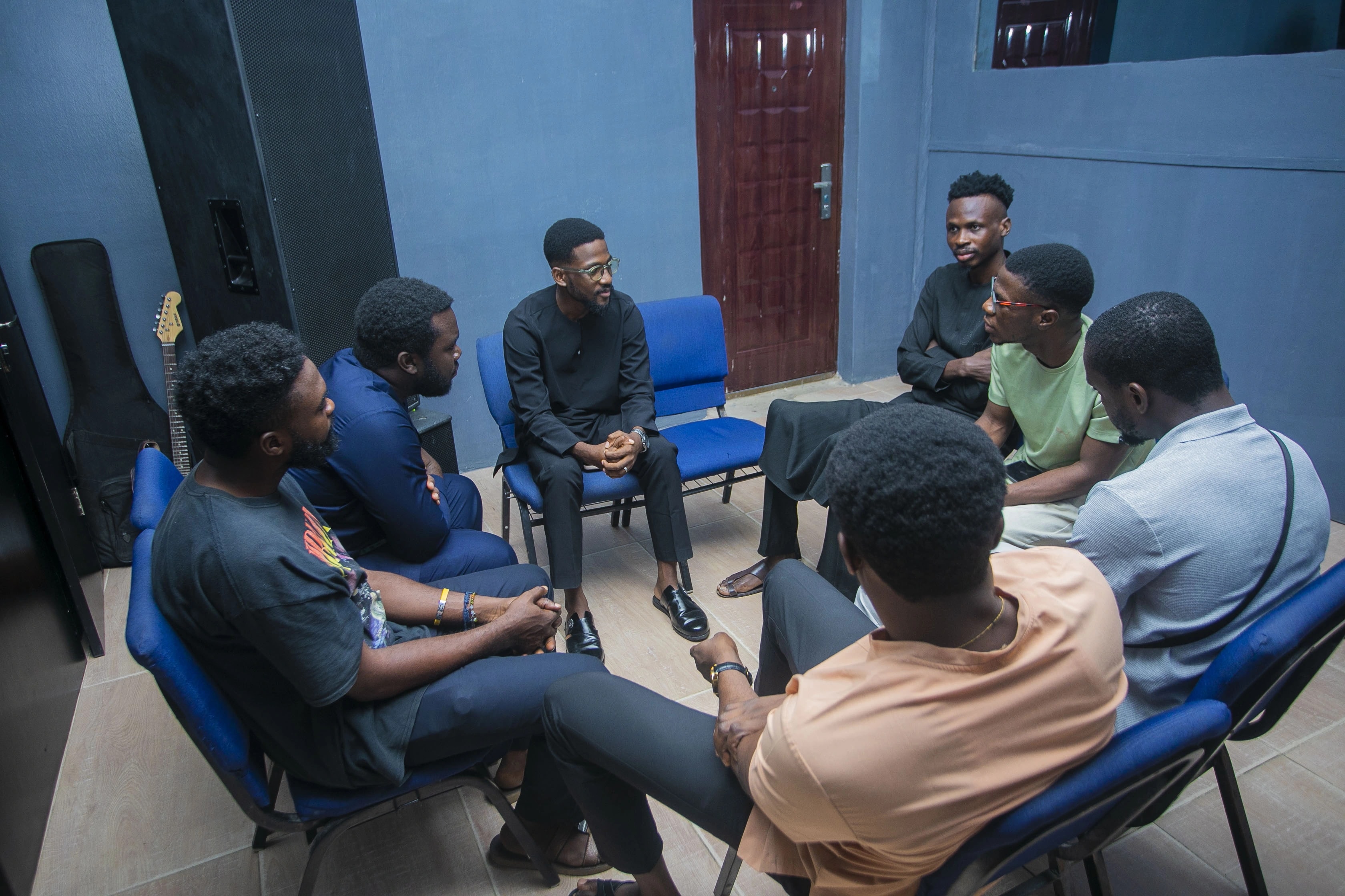 A small group of men turned towards each other in conversation