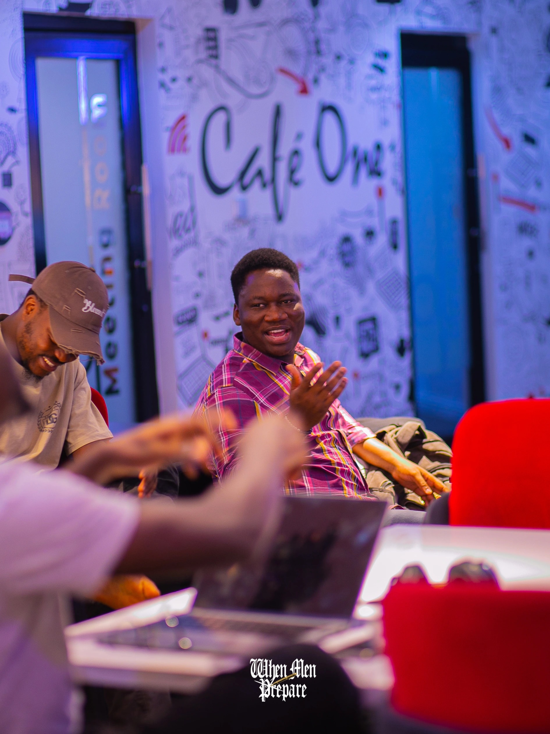 A man laughing with the men around him at a table